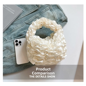 Top view of a white ruffled satin handbag with pleated textures on a denim jacket