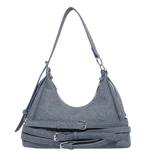 Sac hobo en denim bleu-gris avec brides décoratives à boucles argentées sur fond blanc