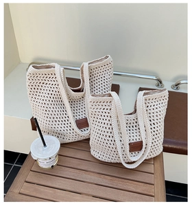 Dettaglio della borsa tote all'uncinetto avorio con etichetta in pelle marrone goffrata