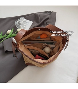 Macro view of woven straw tote bag interior showing spacious compartments and brown leather trim