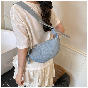 Close-up of light blue croissant shoulder bag with pleats and adjustable wide strap