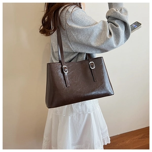 Detail shot of the dark brown retro embossed leather tote bag with silver metal buckles