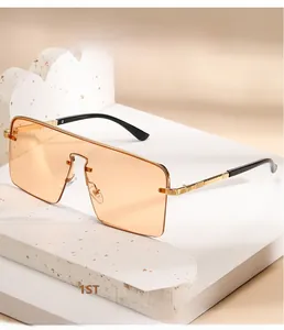 Détail de lunettes de soleil carrées orange oversize avec branches fines dorées