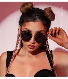 Detail of trendy oversized sunglasses with metallic frames and dark lenses on a fashion model
