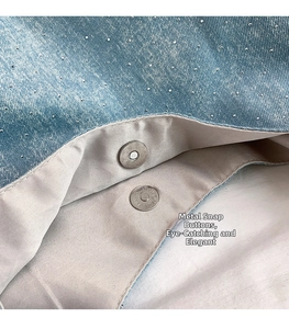 Detail of silver magnetic snaps on a denim tote bag with subtle sparkling rhinestone accents