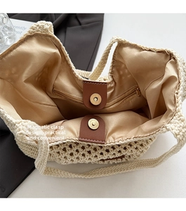 Detail view of woven tote bag showing beige fabric lining and magnetic leather closure