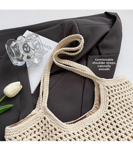 Detail of hand-woven cream tote bag showing hollow crochet patterns and broad shoulder strap