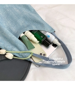 Detailed interior of a large denim tote bag showing spacious storage with personal items