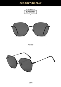 Detail view of black grey geometric sunglasses with slim metal frames and nose pads