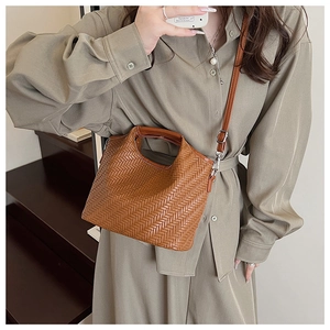 Detailed view of brown woven texture shoulder bag worn as a stylish crossbody bag