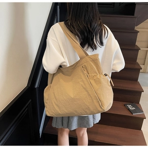 Detail view of khaki canvas tote bag side drawstring pocket and wide shoulder strap
