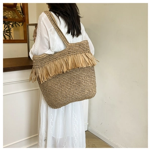 Detailed view of handmade woven tassel shoulder bag with bohemian fringe design
