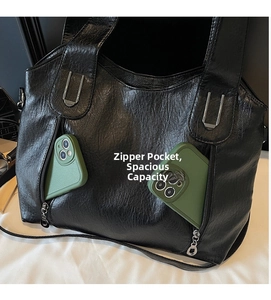 Detail of black tote bag showing dual zipper pockets with spacious interior capacity