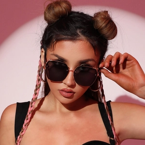 Fashion oversized sunglasses with gold metal frame and dark lenses on female model