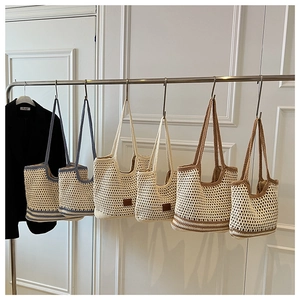 Close-up of woven crochet shoulder bags in assorted colors hanging on metal racks