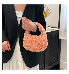Detail of soft pleats and lace stitching on the apricot pink designer handbag