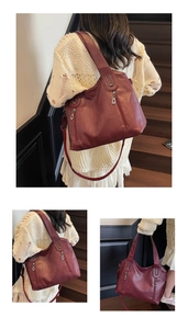 Macro detail of wine red leather tote featuring vertical zippers and metallic hardware