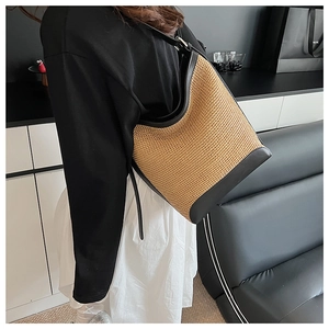 Gros plan détaillé du sac à bandoulière en paille tressée avec bordure en cuir noir chic