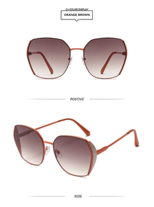 Detail view of orange oversized sunglasses with brown gradient lenses and metallic temples
