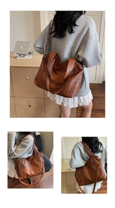 Close-up of brown tote bag with multiple zipper pockets and fine leather texture details