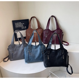 Group of colorful large tote bags with dual metal zippers and adjustable straps on display