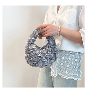 Detail of silver gray pleated satin mini handbag featuring delicate ruffled texture