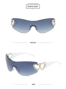 Detail view of white Y2K sunglasses with heart-shaped metal accents and gray lenses