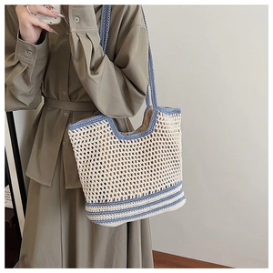 Dettaglio di una borsa tote grande all'uncinetto con bordo blu e trama a rete