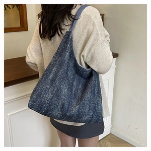 Detail of dark blue denim tote bag with white snowflake texture and large capacity