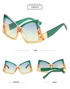 Detail view of oversized butterfly sunglasses with green and tortoiseshell frames and gradient lenses