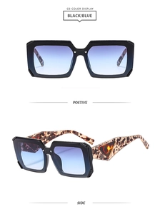 Detail of square black sunglasses with blue gradient lenses and gold triangle logo