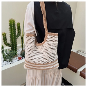 Detail of hollow crochet texture and brown stripes on ivory knit tote beach bag
