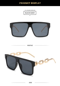 Detail of square oversized black sunglasses with luxury gold metal chain temples