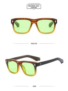 Détail de lunettes de soleil carrées bicolores avec verres verts et rivets argentés