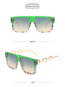 Detail of square green sunglasses with gold chain temples and gradient lenses