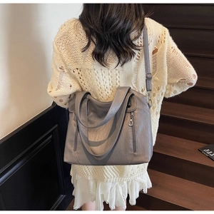 Detail of grey PU leather tote bag showing adjustable strap and silver hardware accents