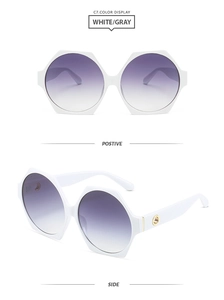 Detail of white hexagonal oversized sunglasses with gradient lenses and gold ornaments