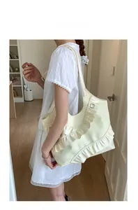 Detail of off-white nylon tote bag featuring aesthetic ruffles and soft pleats