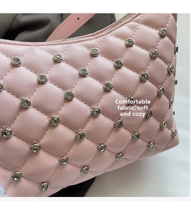 Close-up of pink quilted crossbody bag with silver rhinestones and soft PU leather texture