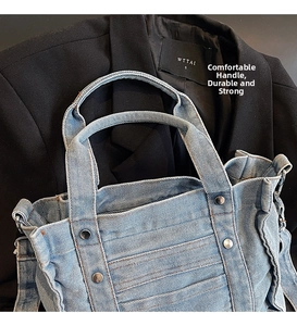 Detailed macro of denim tote bag with metallic rivet accents and light wash finish