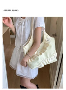 Detail view of cream white tote bag featuring layered ruffle design and soft faux leather