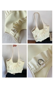 Macro view of cream shoulder bag with layered ruffles and elegant silver D-ring hardware