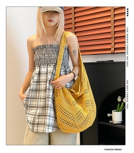 Detail of yellow hollow knit shoulder bag showing V-pattern crochet texture and strap