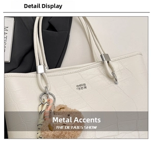 Détail du sac cabas blanc motif crocodile avec finitions argentées et breloque ours
