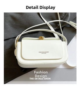 Detail view of white leather crossbody bag showing golden twist lock and logo texture