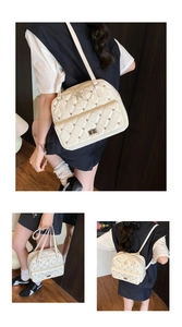 Detailed view of beige quilted bag featuring silver star emblem and studded metal accents