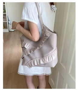 Close-up of a light purple ruffle tote bag with tiered wavy frills and leather texture