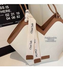 Detail of white and brown contrast tote bag with unique V-shaped opening and canvas strap