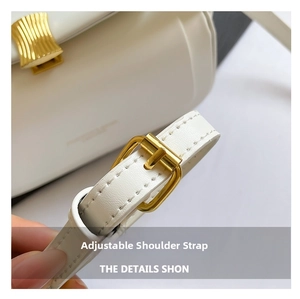 Detail of adjustable white leather shoulder strap with gold metal buckle and precision stitching