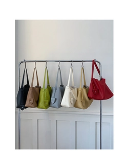 Borse tote multicolori in pelle con grana litchi appese al supporto con tracolle